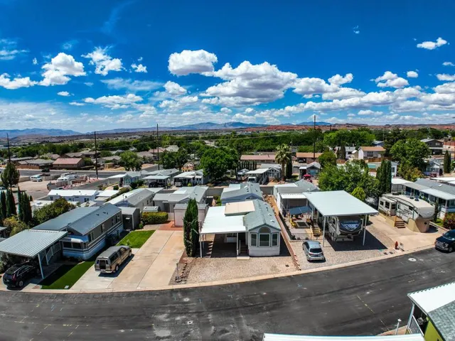 Residential community featuring individual properties with carports, paved driveways, and landscaped areas