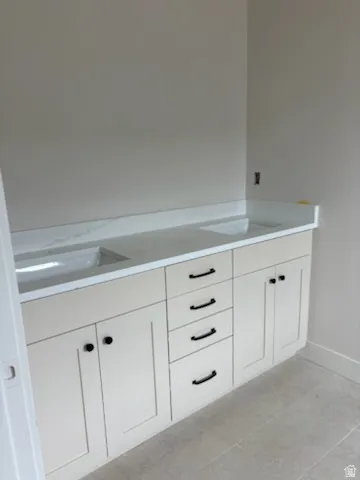 Dual vanity in primary bath with integrated sinks and white countertops