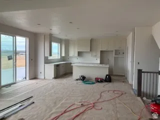 Spacious kitchen area featuring light-toned cabinetry, a central island, and recessed lighting