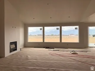 Expansive room featuring multiple large windows, recessed lighting, and an integrated fireplace