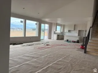 Open-concept living area with large windows, mountain scenery, and a sliding glass door