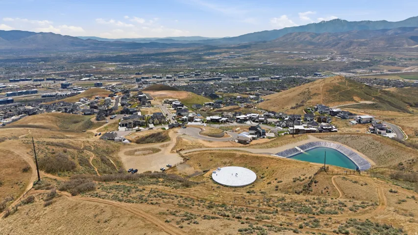 Expansive aerial landscape showcasing a developing hillside community with established homes
