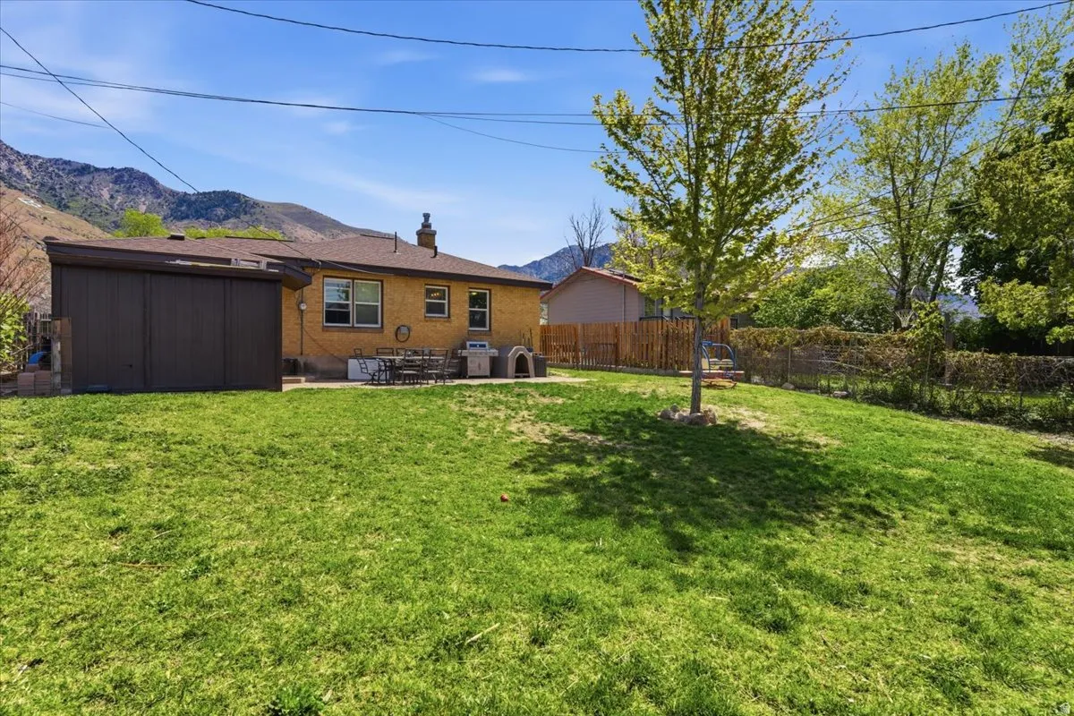 Spacious backyard featuring a sloped lawn and mature trees