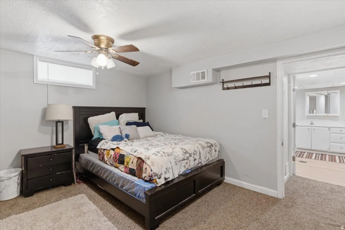 Carpeted room with a ceiling fan light fixture and a high horizontal window