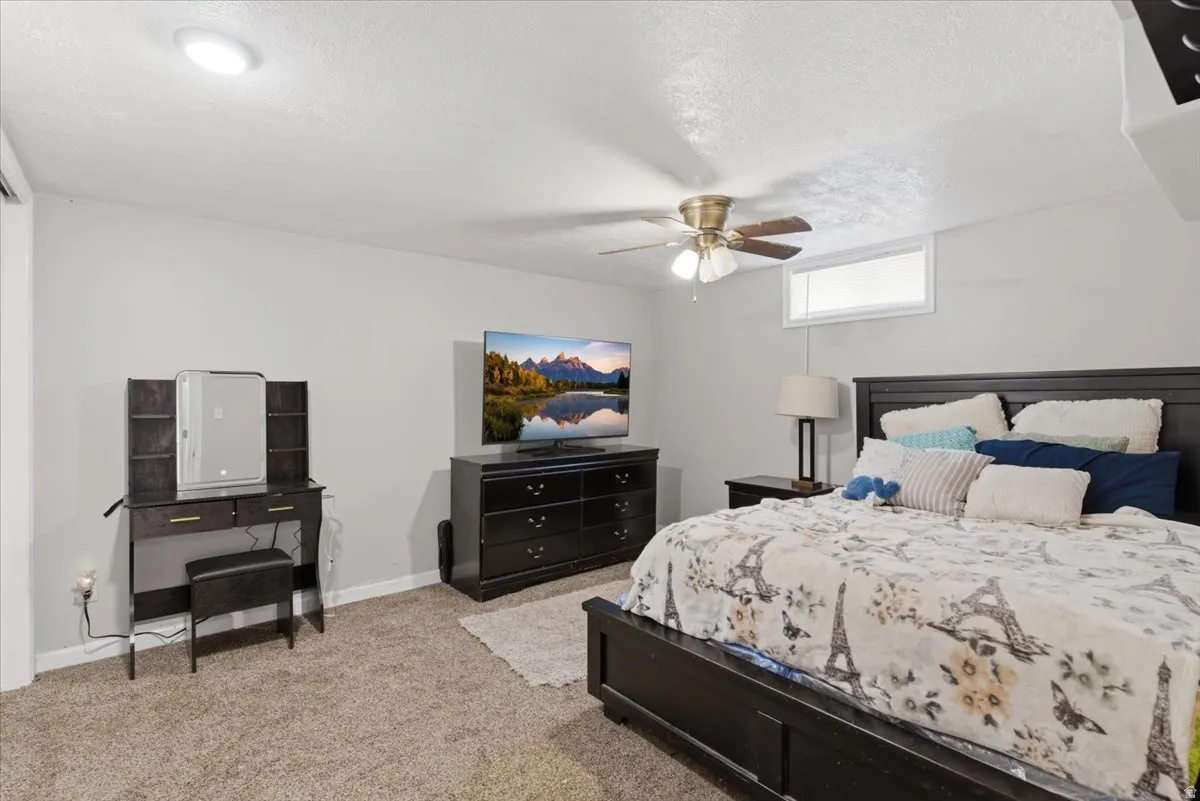 Bedroom featuring neutral carpeting, light-toned walls, and a ceiling fan with integrated lighting