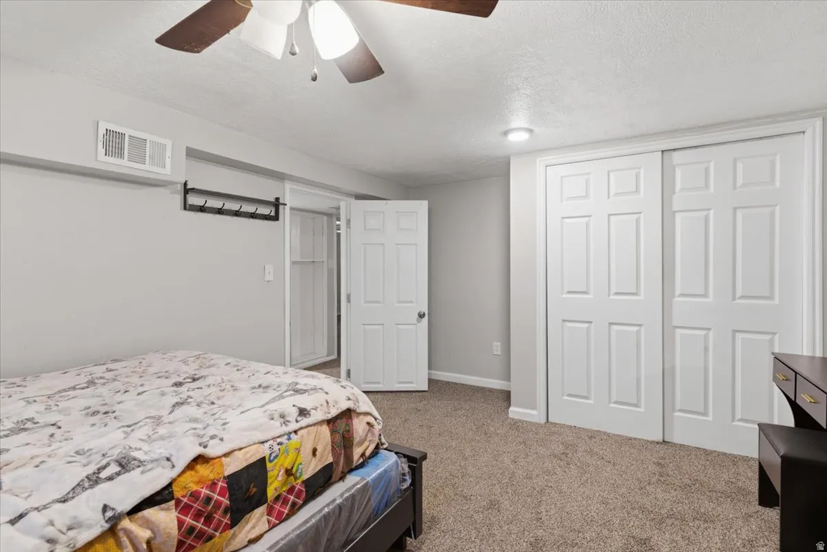 Carpeted room featuring a ceiling fan with integrated lighting, recessed lighting, white trim, and a white six-panel bi-fold closet door