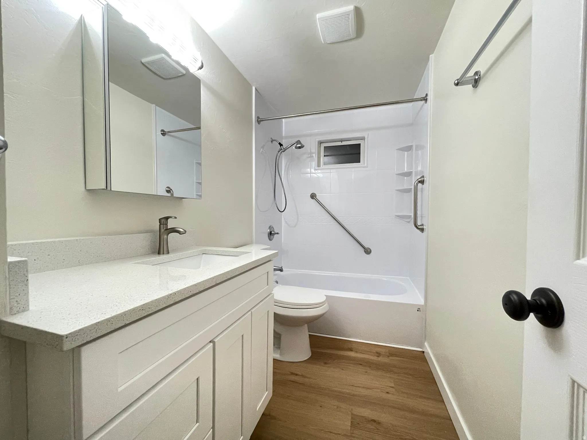 Bathroom featuring a white shaker-style vanity with a light-colored quartz countertop, an undermount sink, and a new brushed nickel faucet