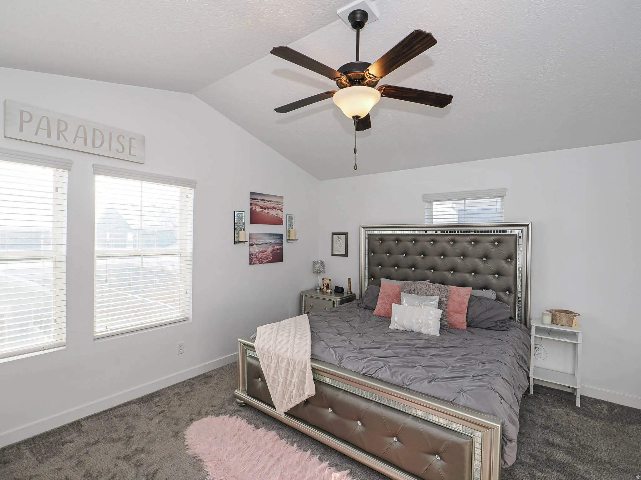 Carpeted bedroom featuring lofted ceiling and a ceiling fan