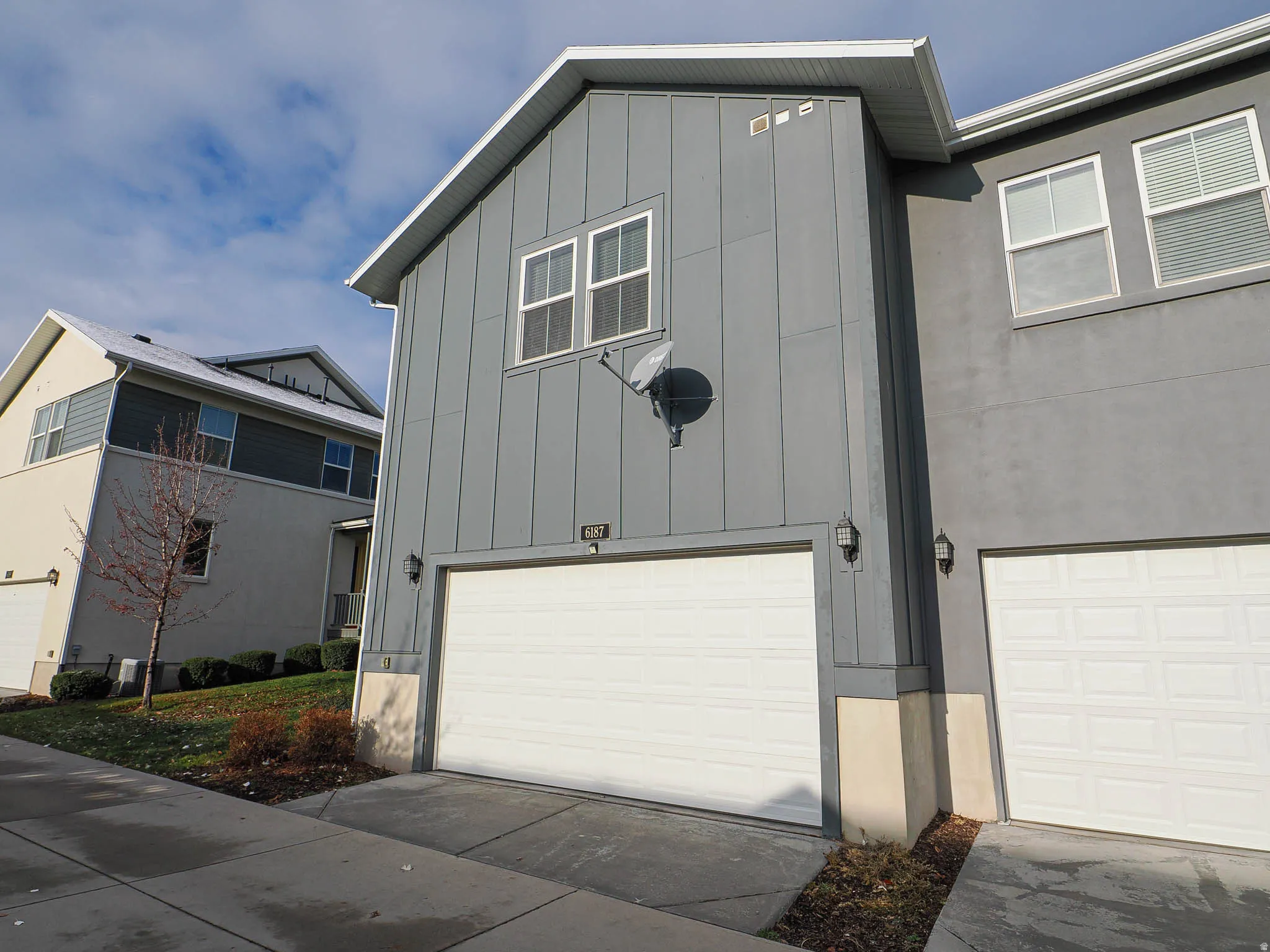 Contemporary exterior with vertical panel siding and stucco finishes