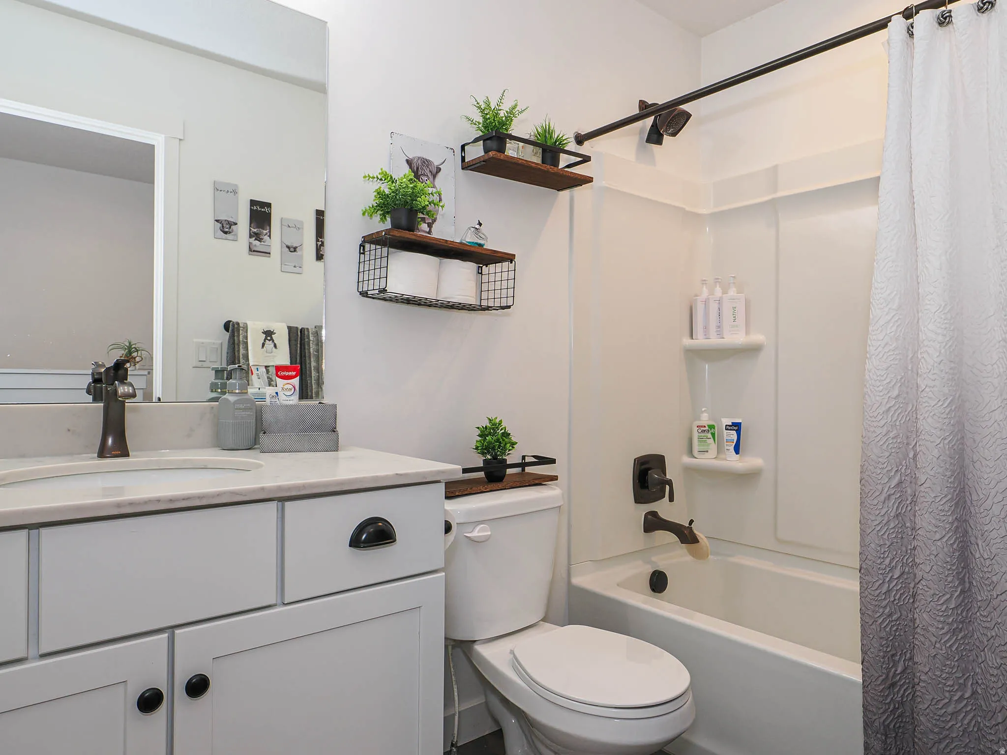 Bathroom with shower / tub combo with curtain and vanity