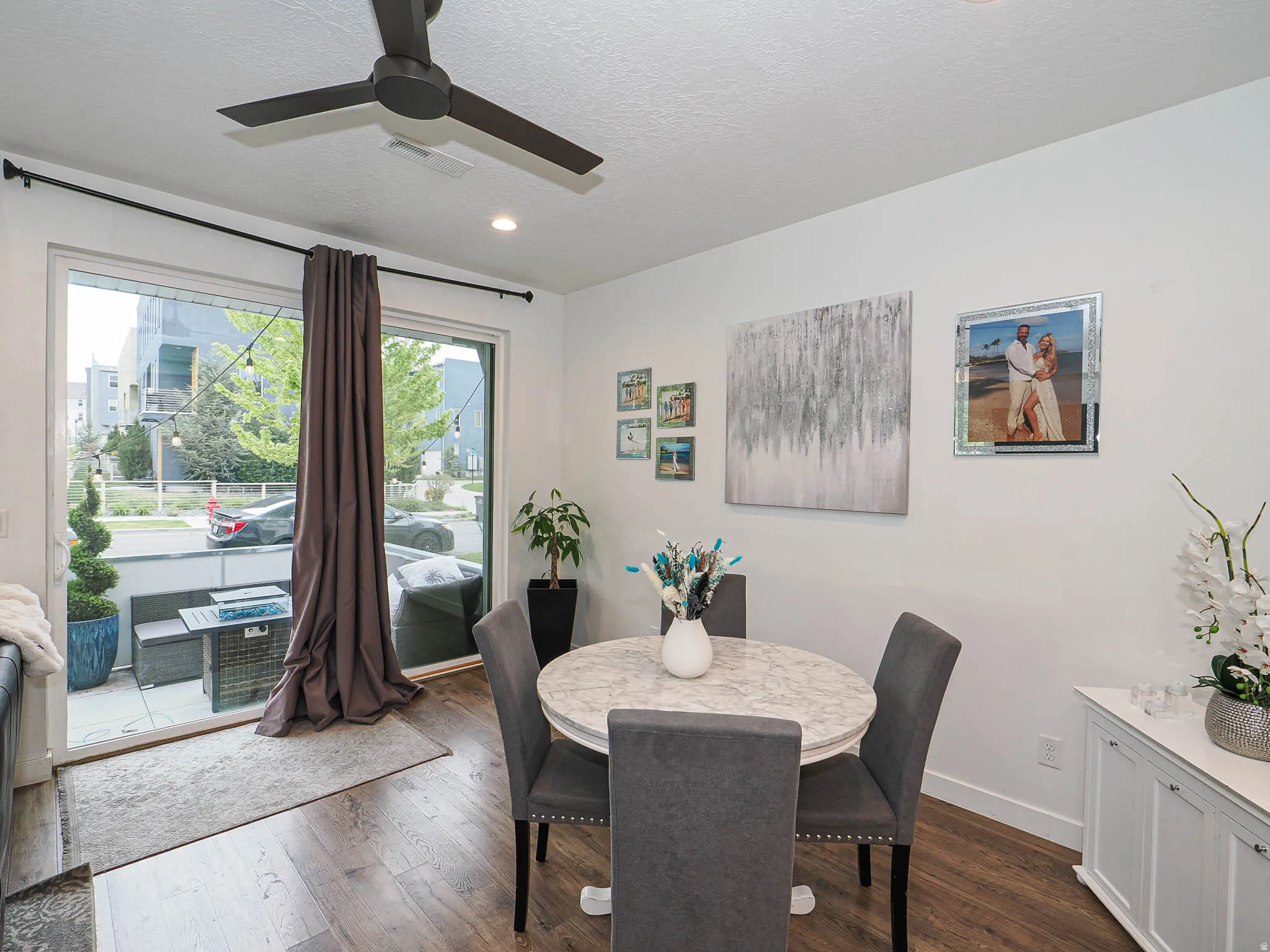 Dining area with wood-finish flooring and a contemporary ceiling fan