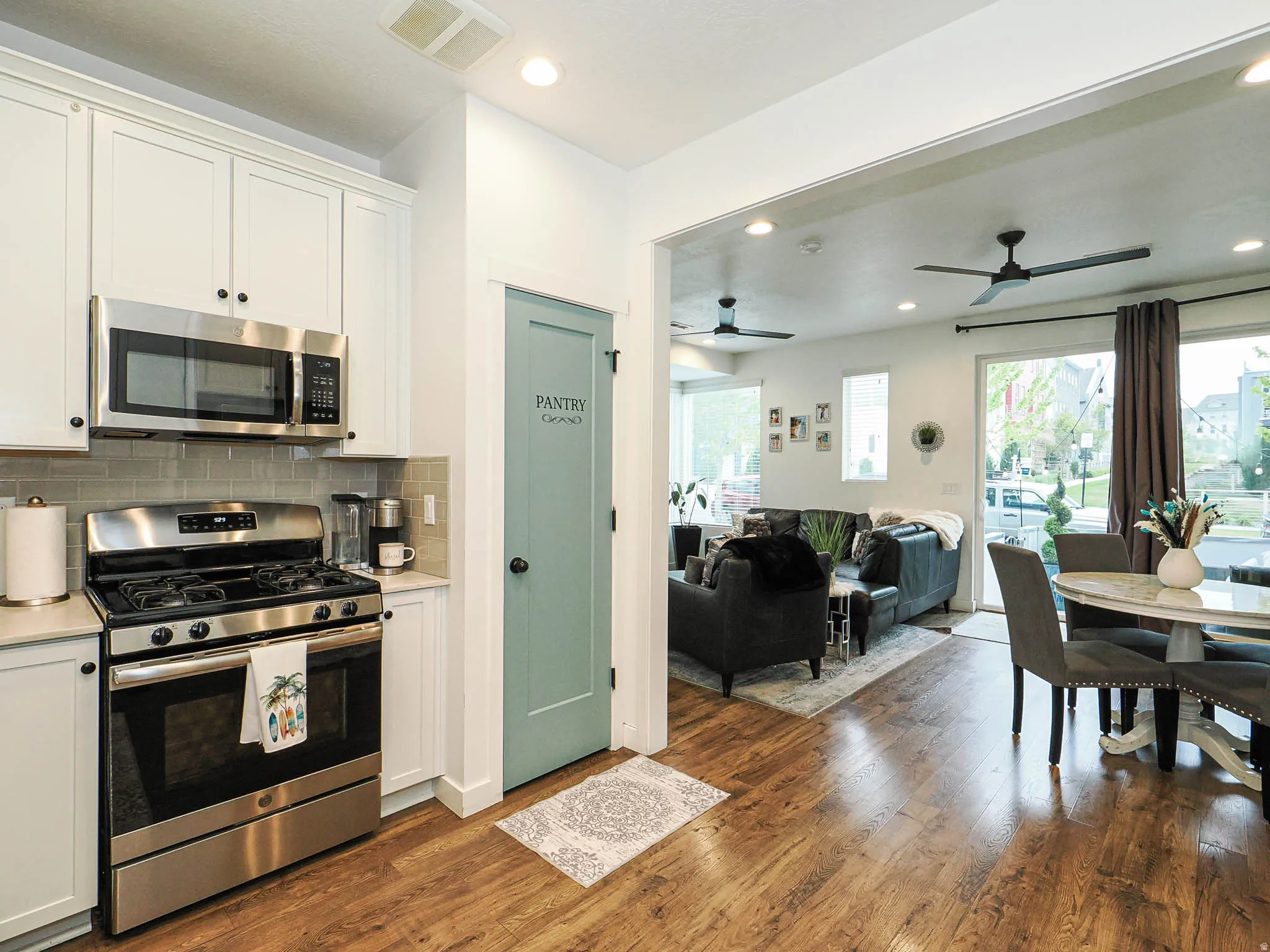 Kitchen featuring stainless steel appliances, white cabinetry, and a tile backsplash