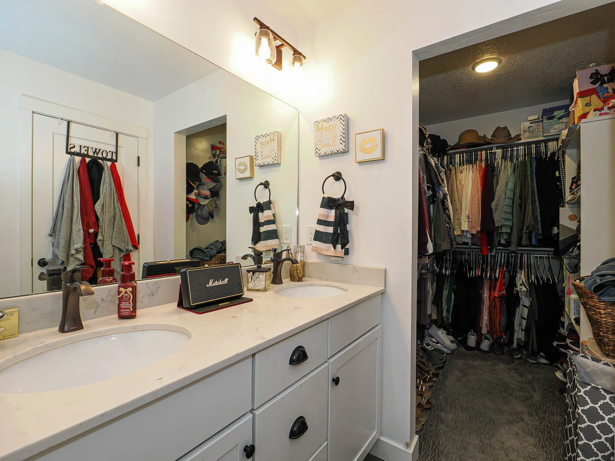 Full bath featuring a spacious closet, double vanity, and dark colored carpet