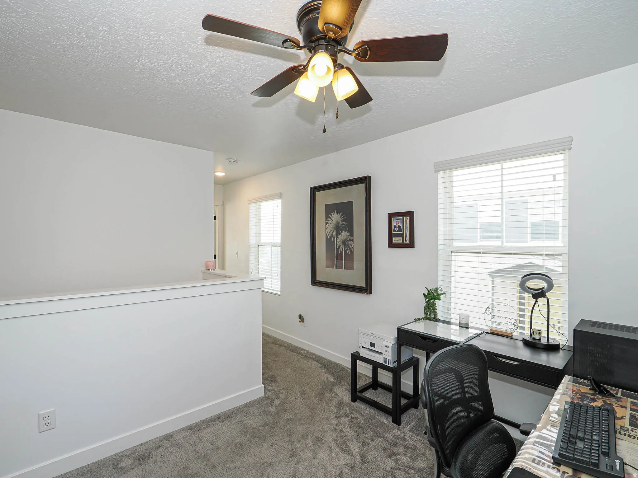 Office space with dark colored carpet, a textured ceiling, and a ceiling fan