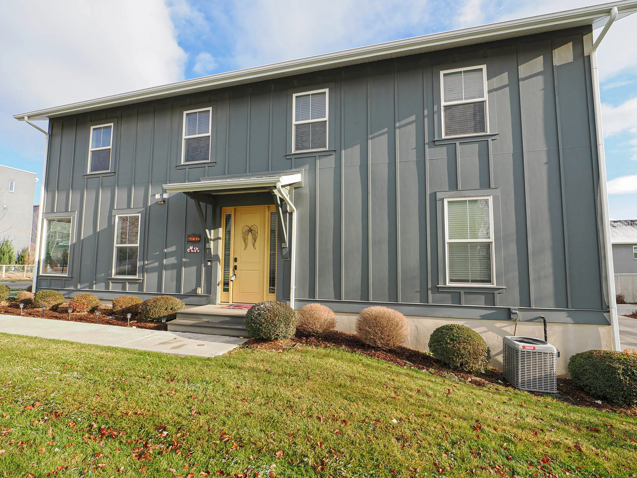 View of front facade featuring board and batten siding and a front yard