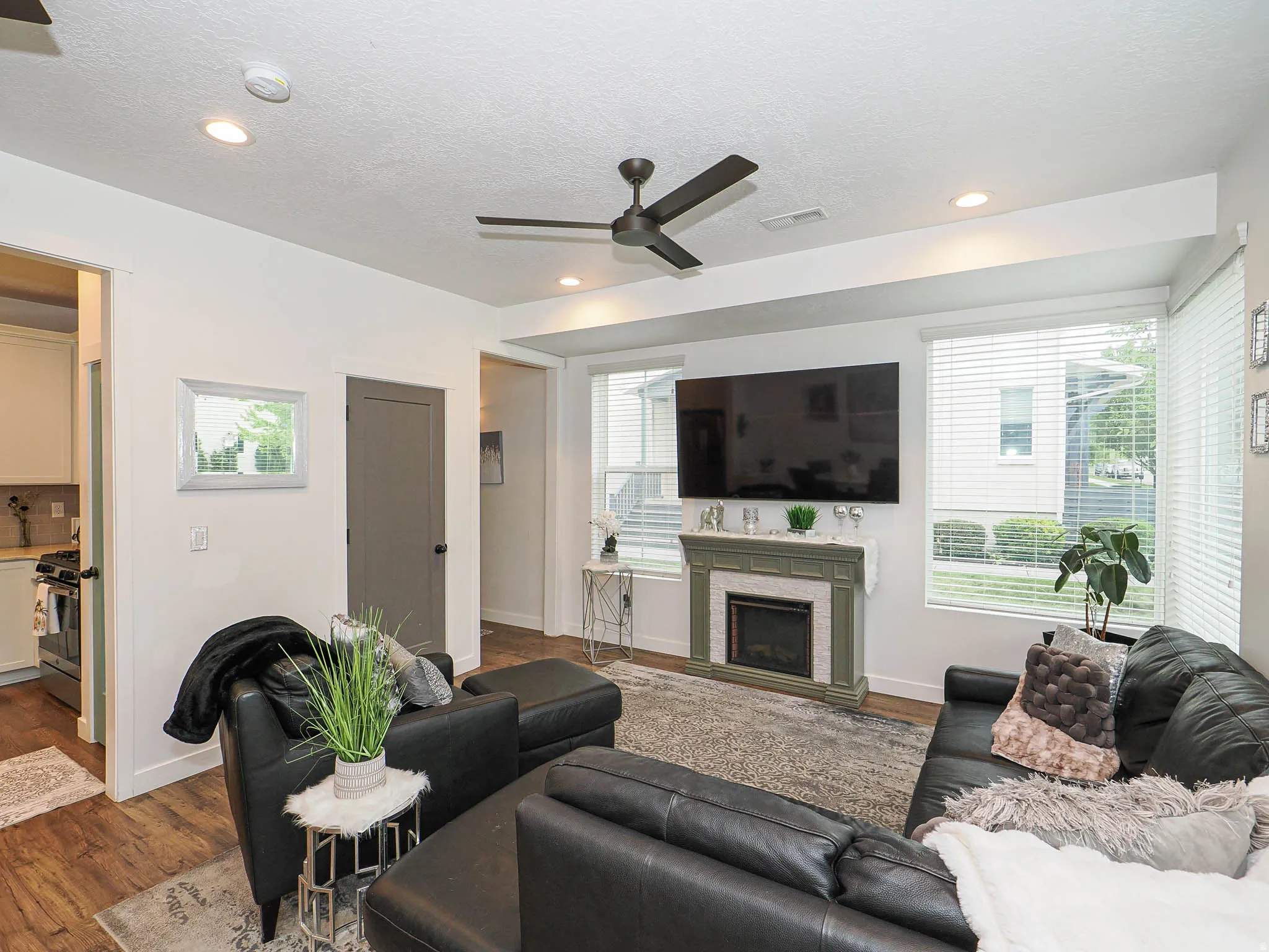 Living area featuring wood-finish flooring, a contemporary ceiling fan, and recessed lighting