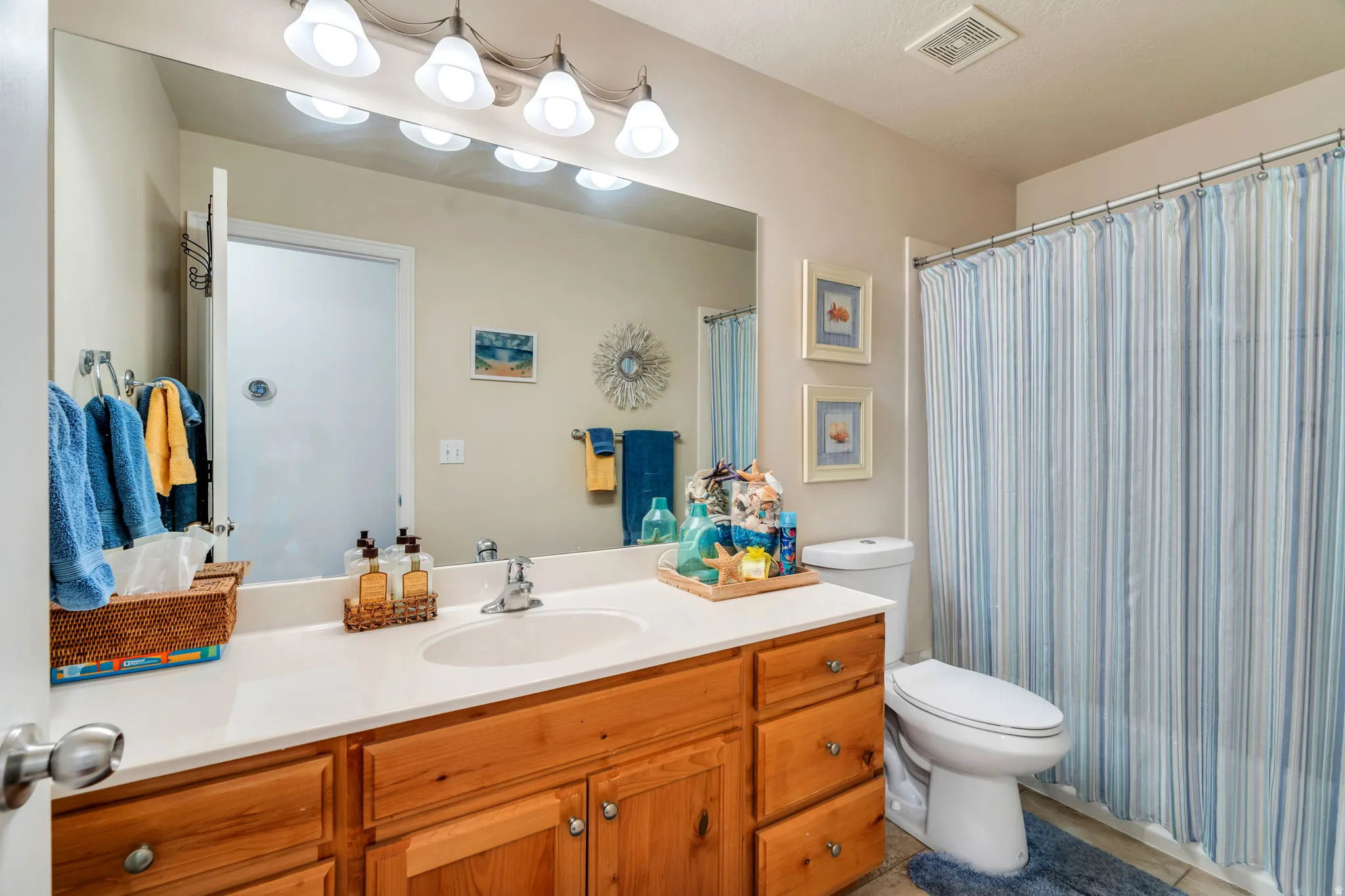 Full bath with vanity, a shower with curtain, and light tile patterned flooring