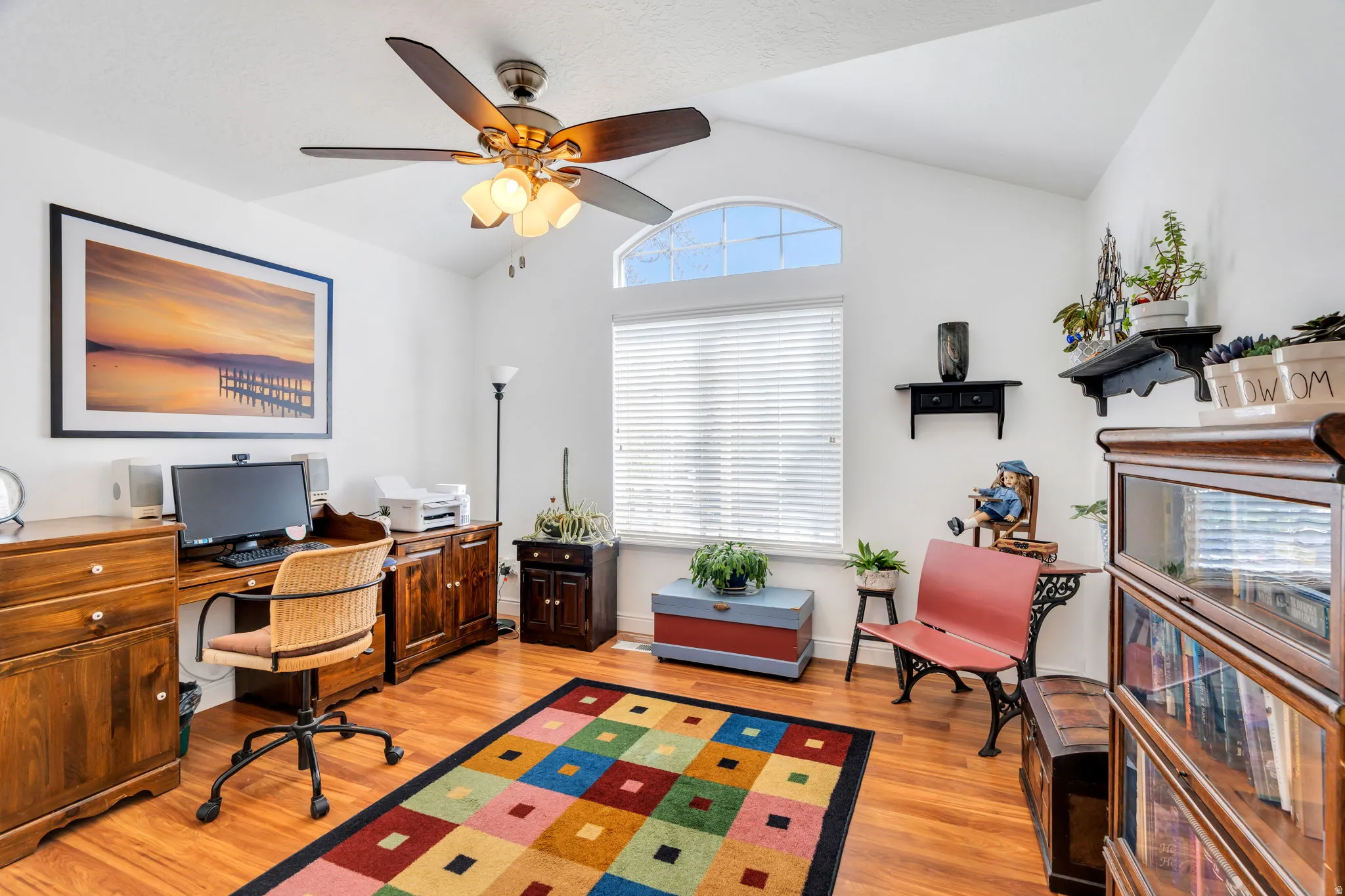 Office featuring light wood finished floors, ceiling fan, and vaulted ceiling
