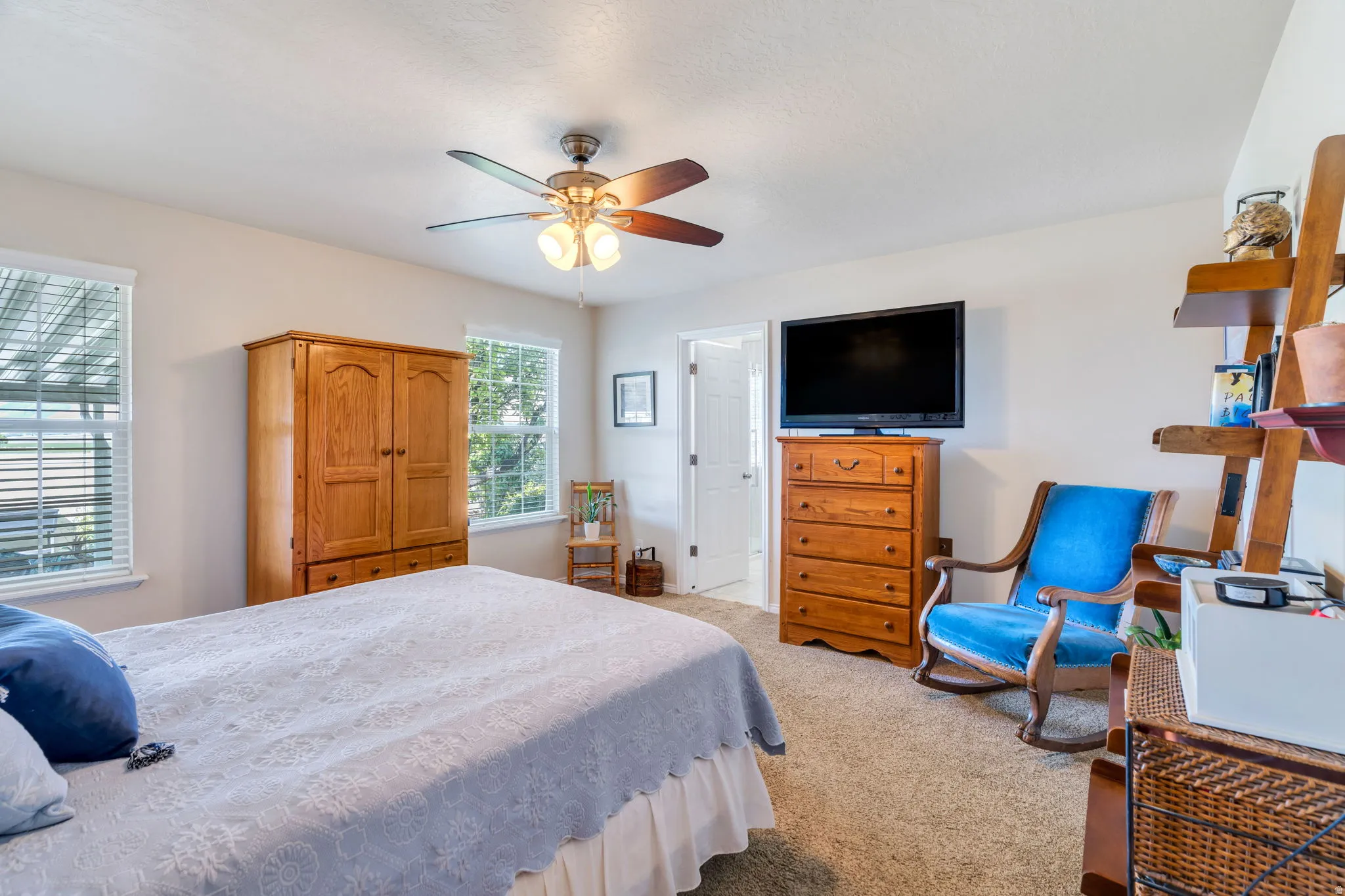 Bedroom with light colored carpet and a ceiling fan