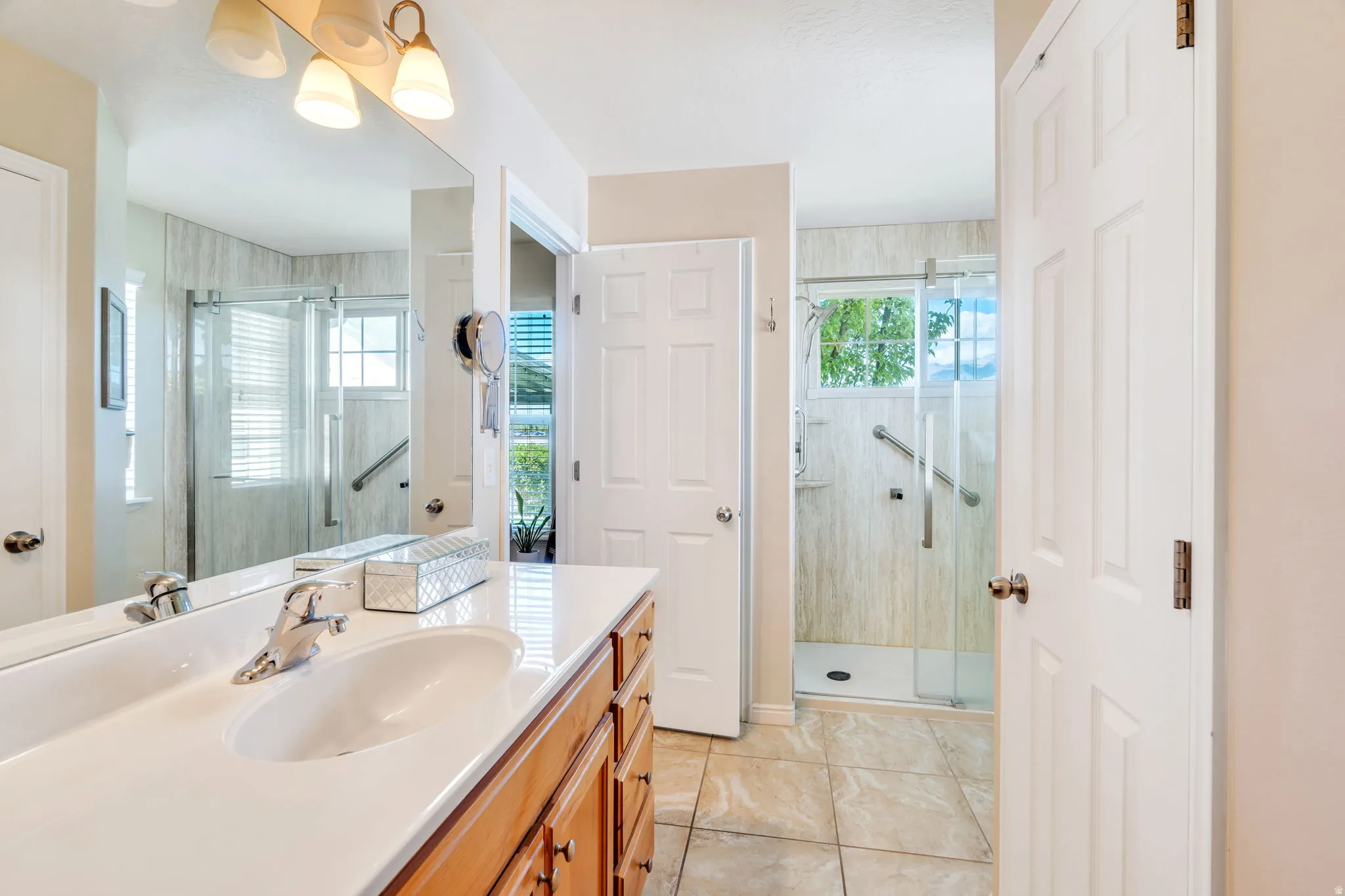Bathroom featuring vanity, a shower stall, and light tile patterned flooring