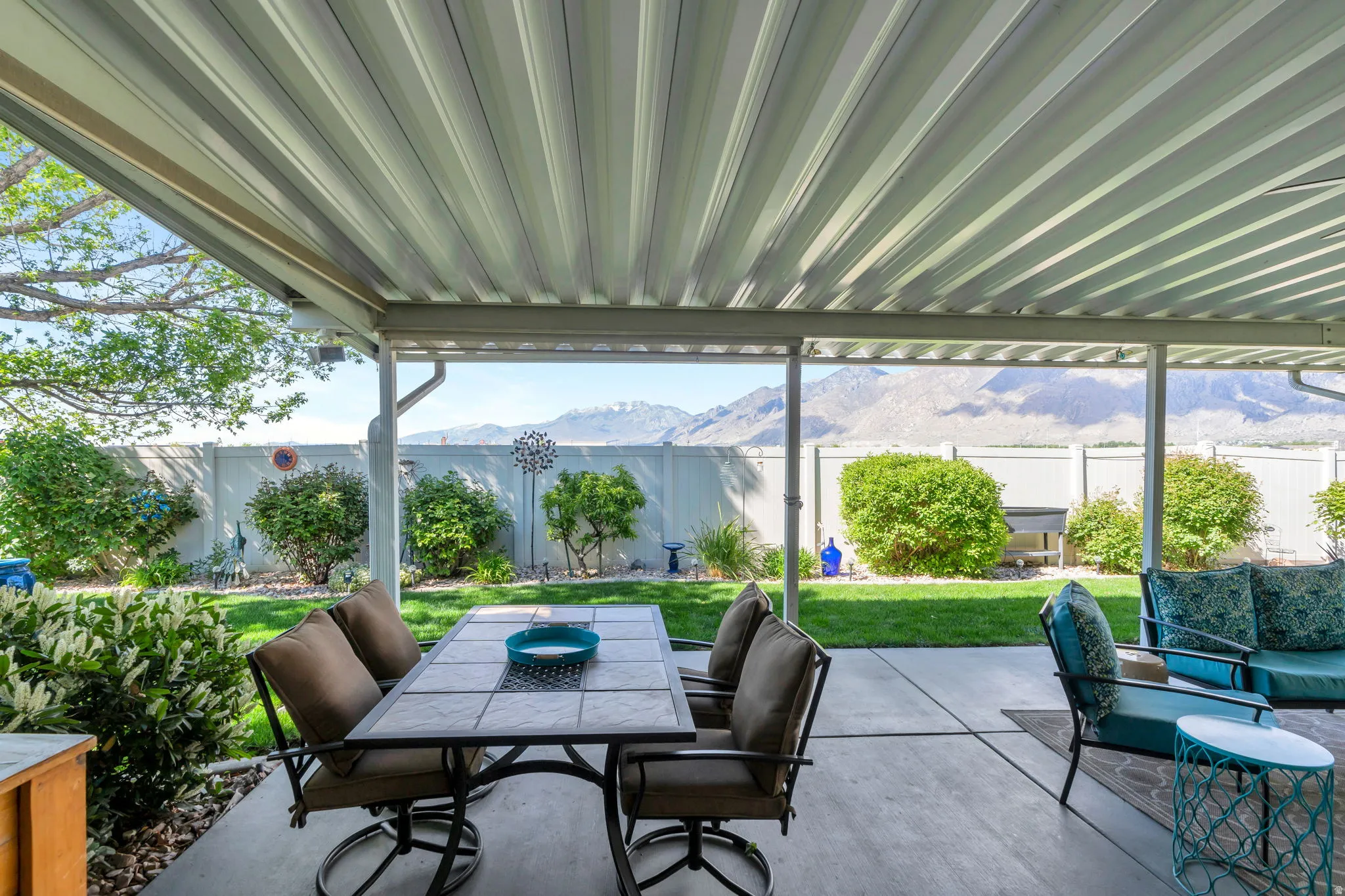 Fenced backyard featuring outdoor dining space, a mountain view, and a patio