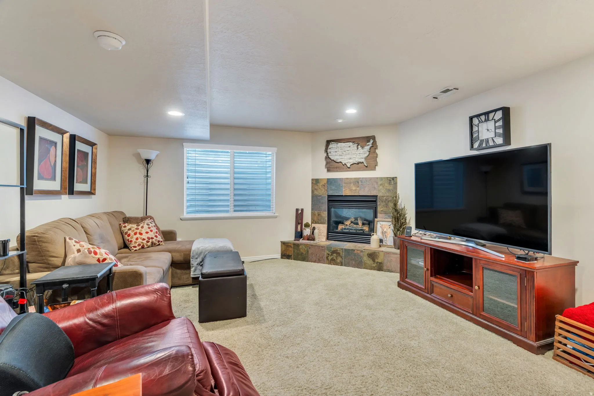 Carpeted living room featuring a tile fireplace and recessed lighting