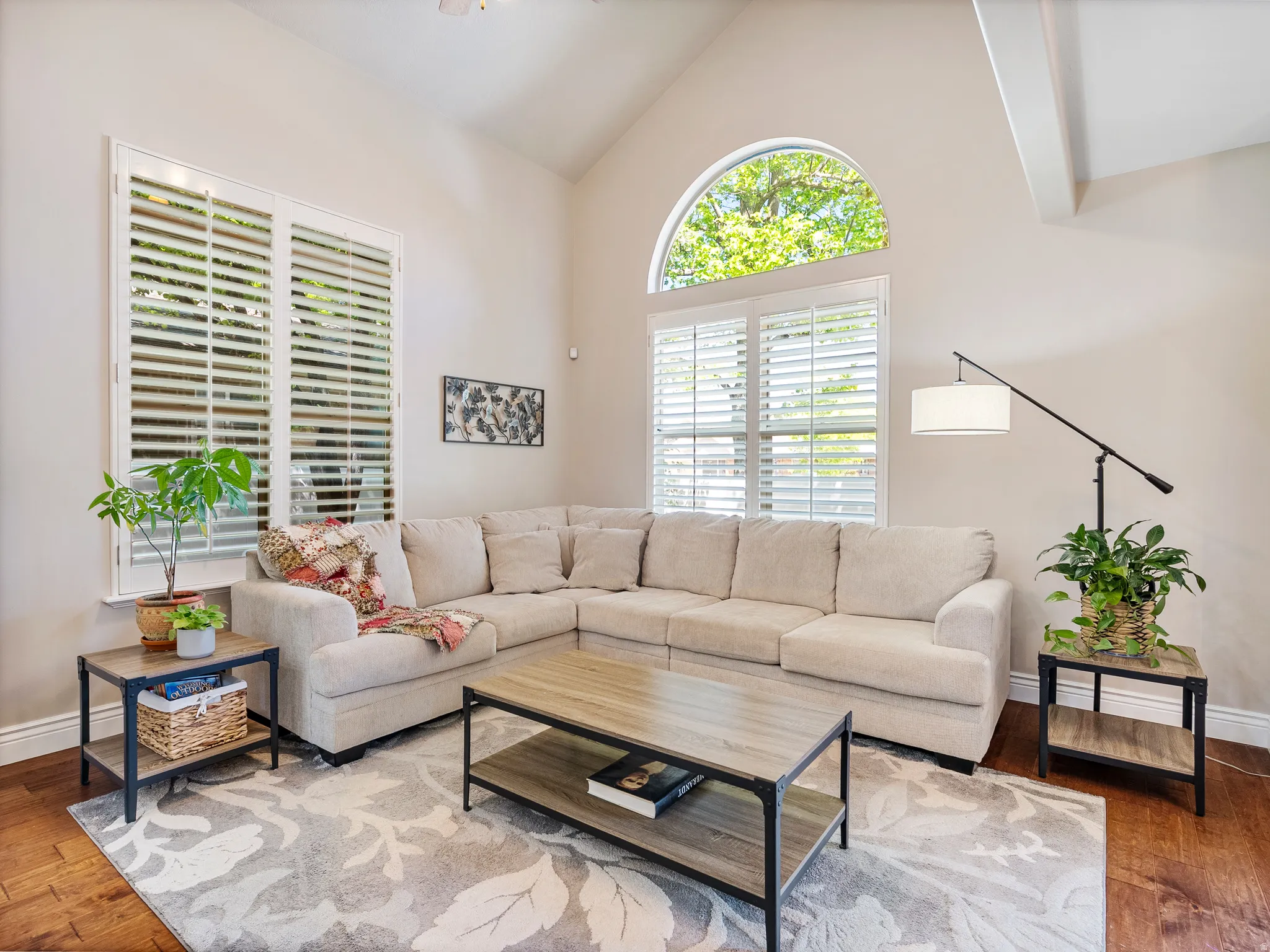 Vaulted ceilings featuring exposed beams and an arched transom window