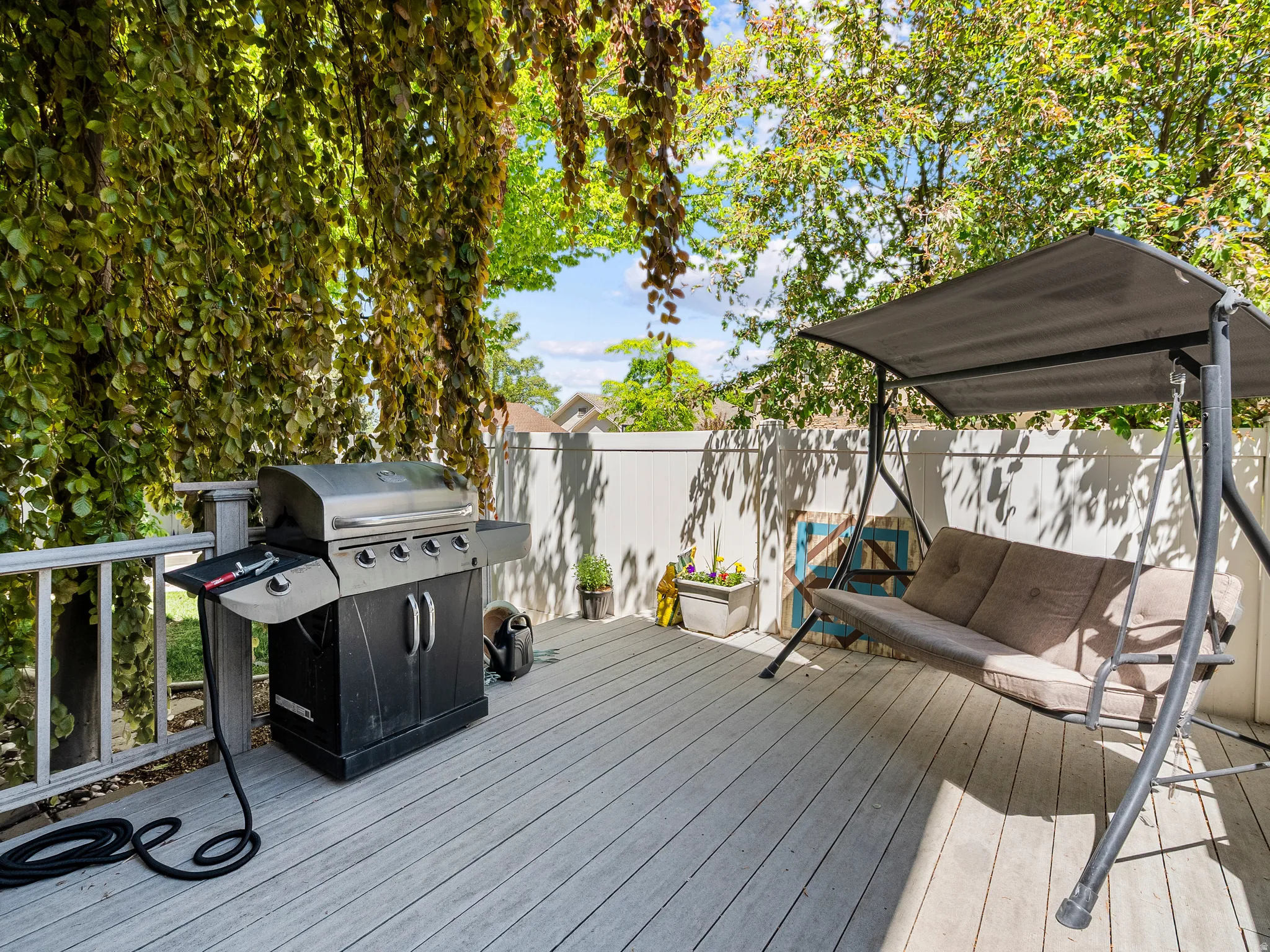 Expansive outdoor deck featuring composite decking, white railing, and a privacy fence