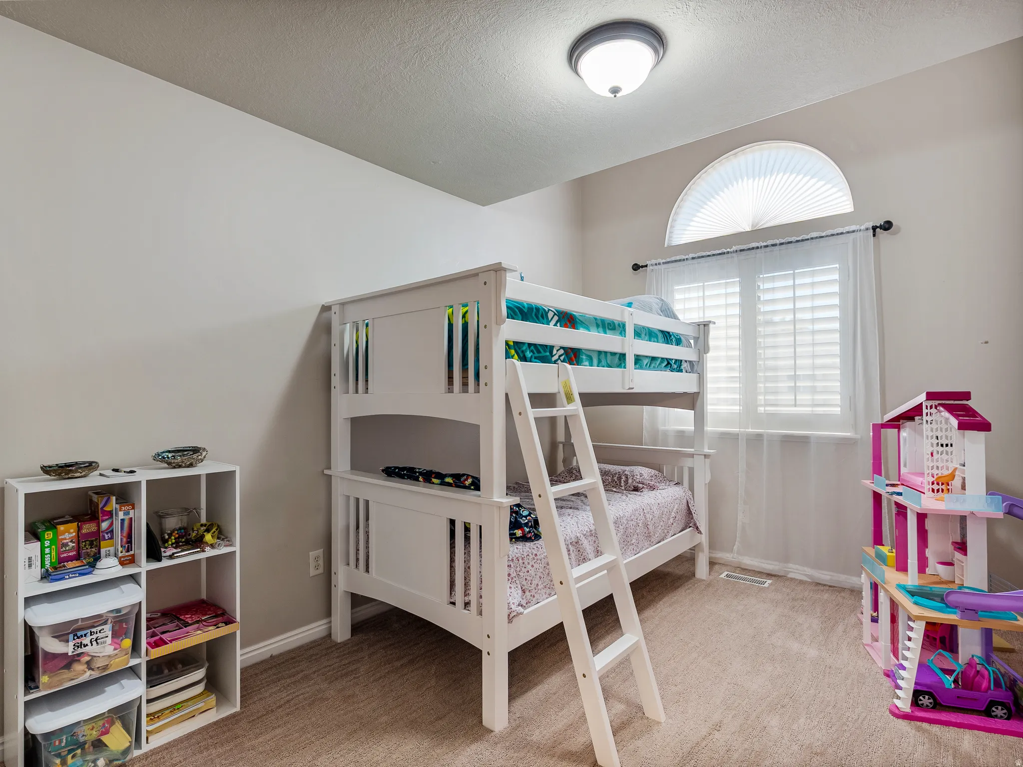 Neutral-toned carpeting and walls complement a window featuring white blinds and an arched transom