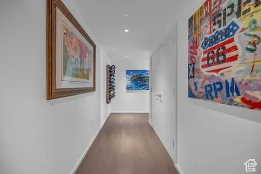 Hallway with dark wood-style flooring and recessed lighting