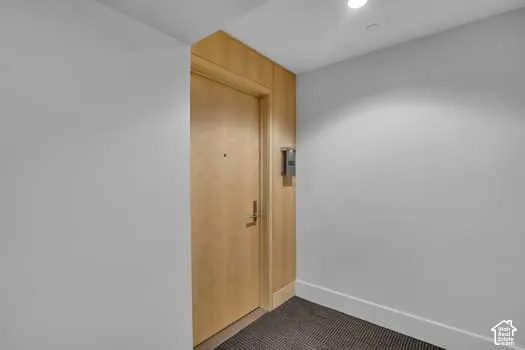 Corridor with baseboards and recessed lighting