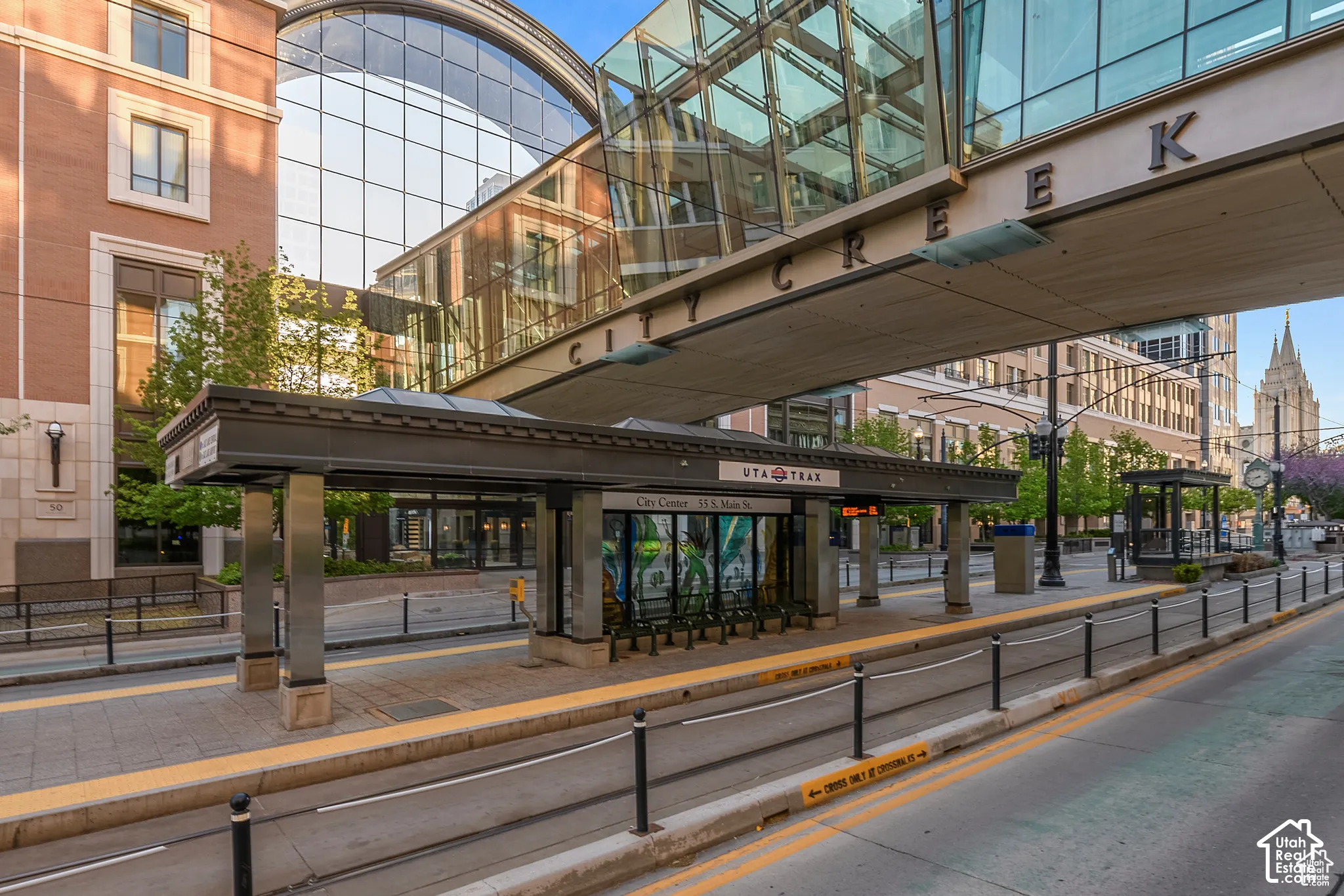 Modern transit platform featuring a shelter with a dark metal roof and stainless steel supports