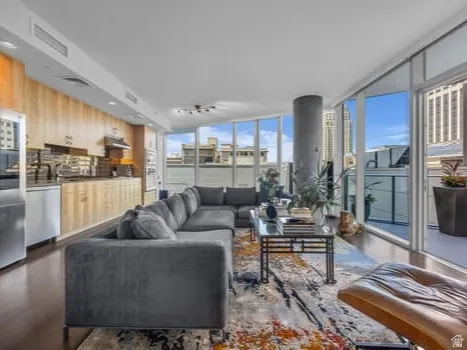 Living area with floor to ceiling windows and dark wood-type flooring