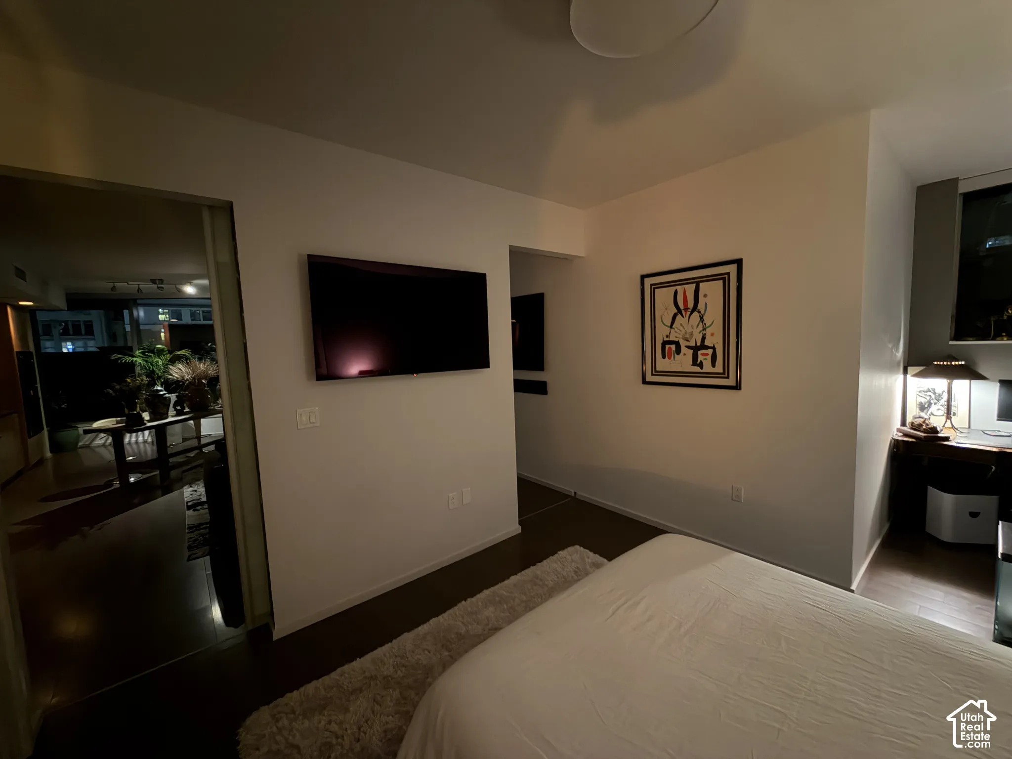 Recessed overhead lighting, dark wood-finish flooring, built-in shelving, and a desk area