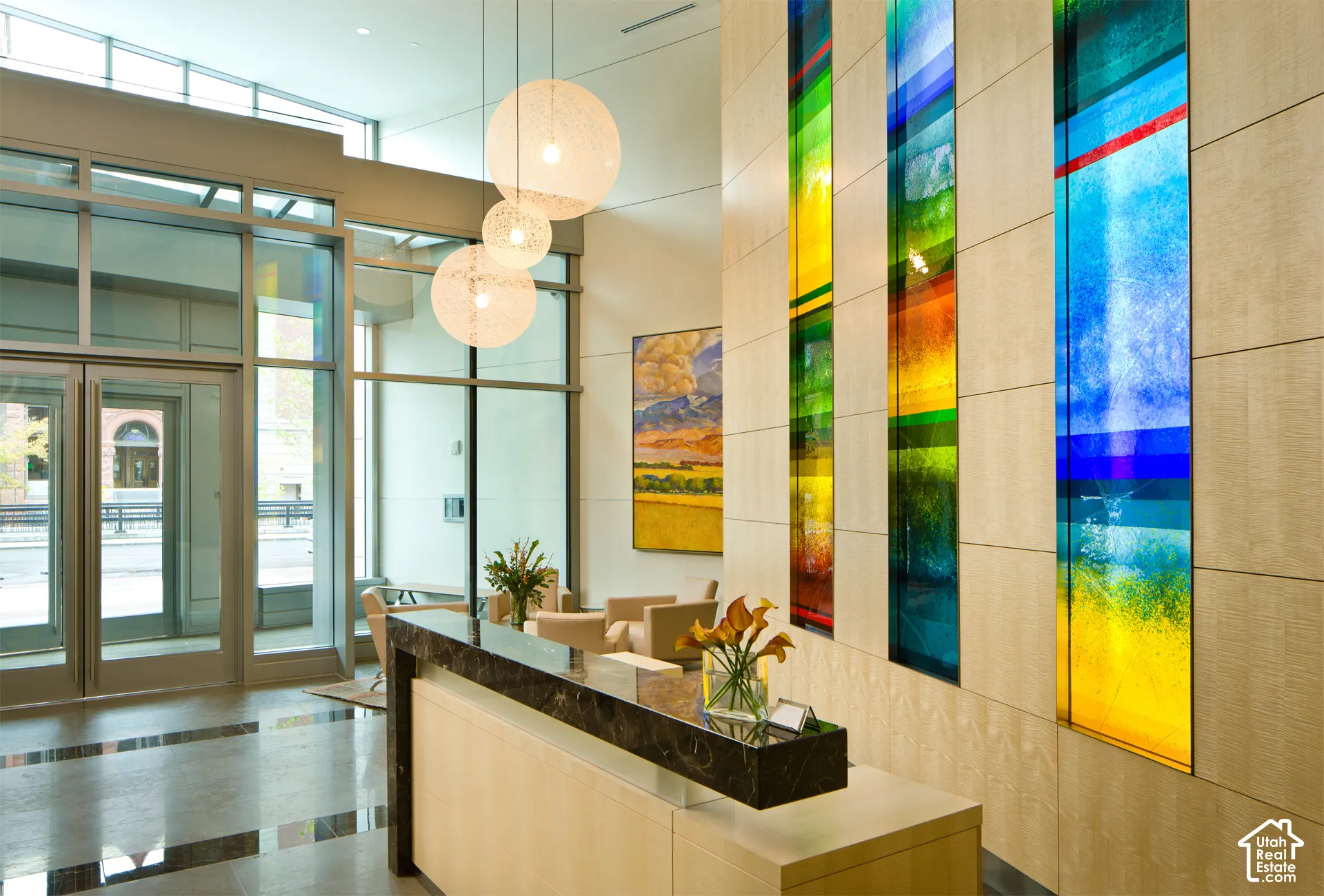 Lobby reception area featuring a polished stone countertop, wood-finish paneling, and integrated colorful art panels