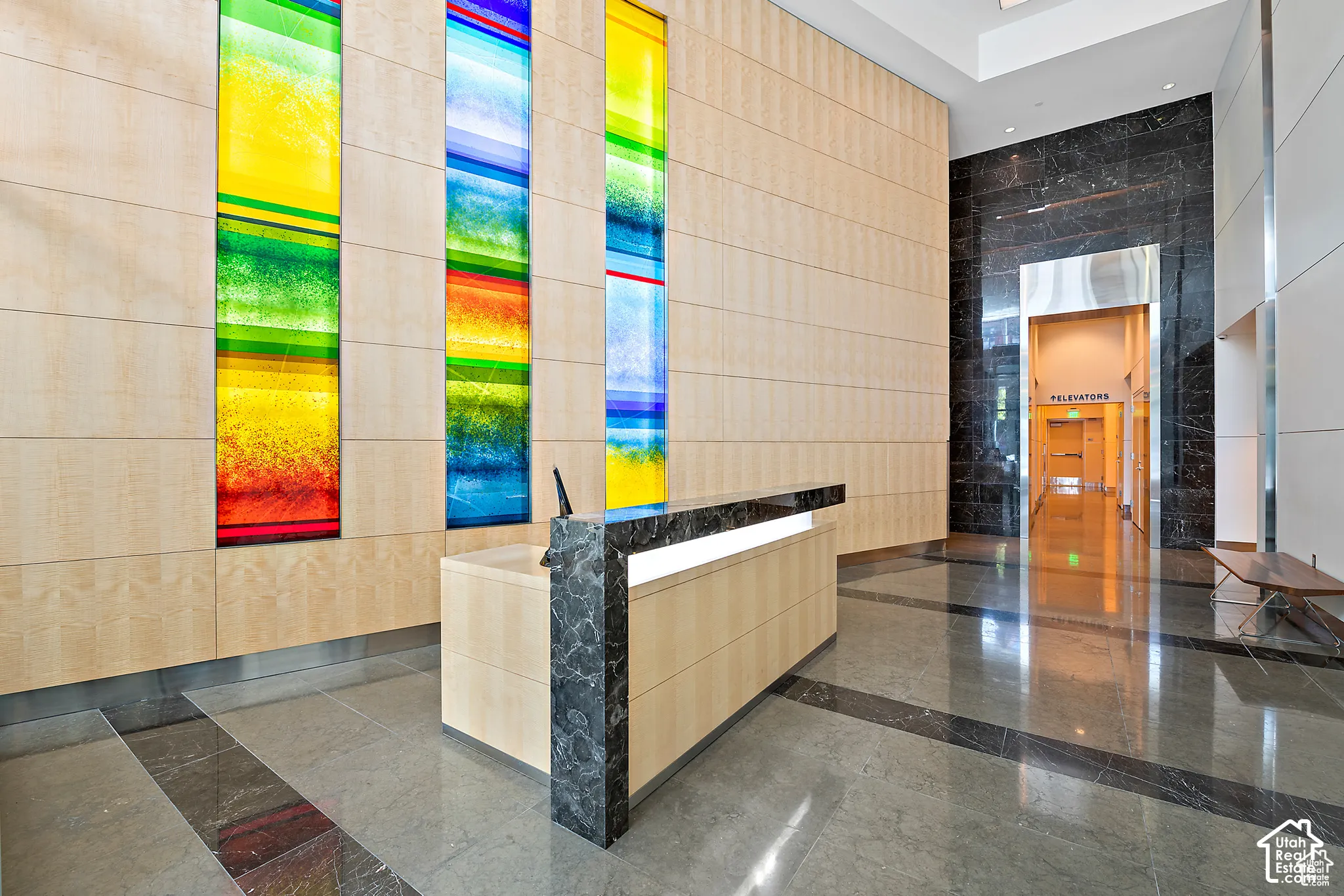 Contemporary reception area featuring a light wood-finish paneled wall with integrated colorful art panels