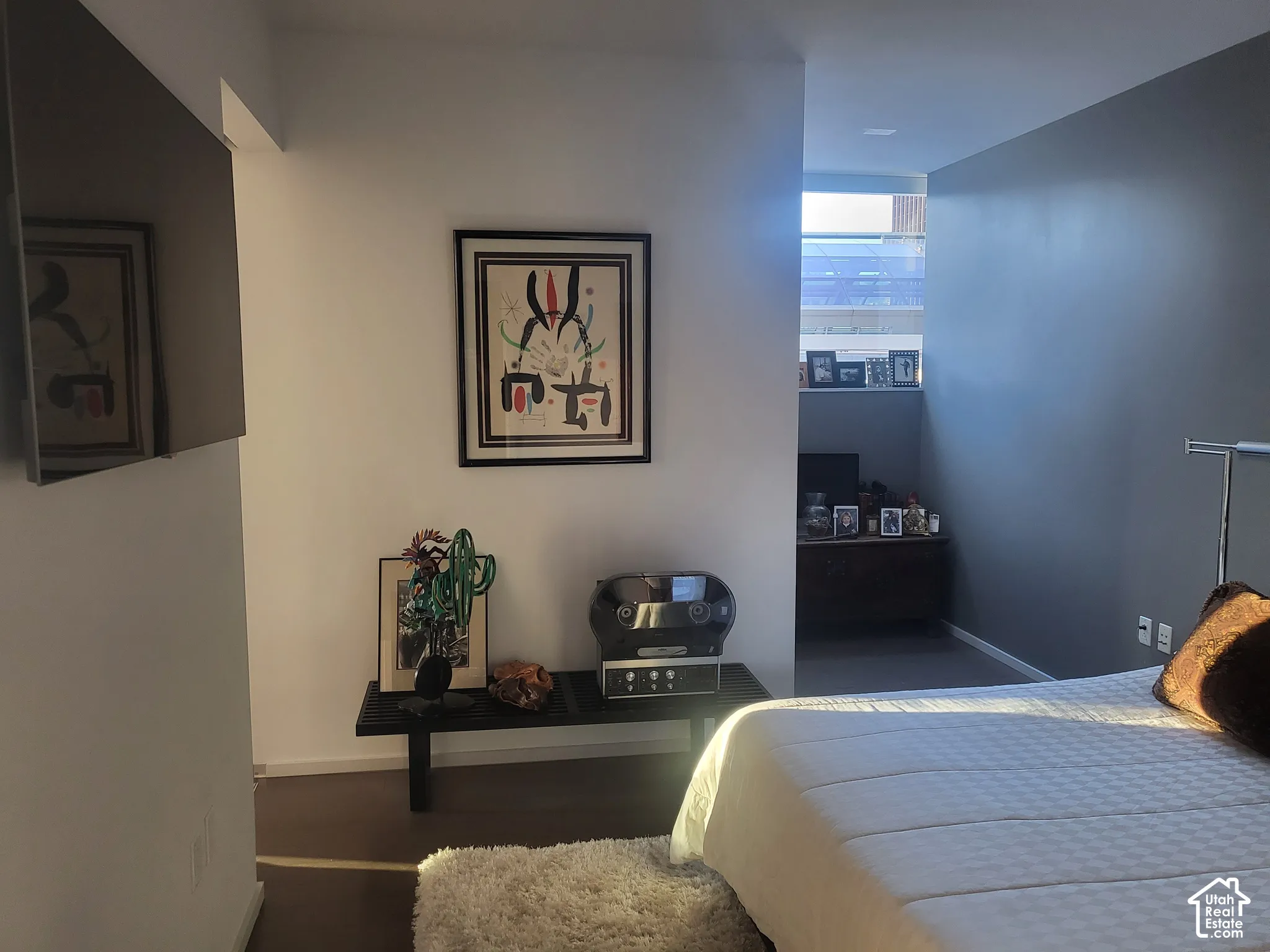 Spacious interior with two-tone walls, wood-finish flooring, and natural light from a high window