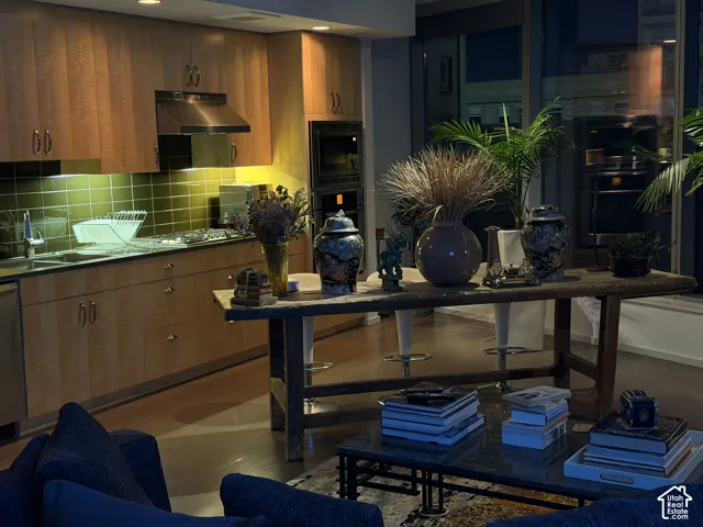 Full-height cabinetry, stainless steel appliances, and a tile backsplash