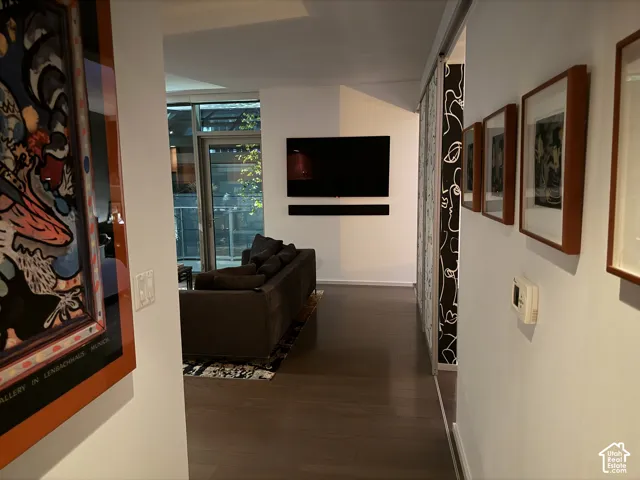 Dark wood-finish flooring throughout, white painted walls, and recessed lighting