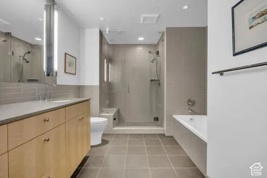 Bathroom with a garden tub, vanity, a shower stall, and light tile patterned floors