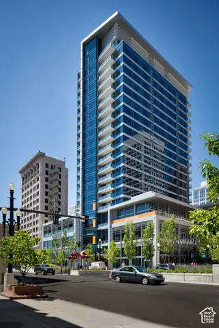 Contemporary high-rise building featuring a blue glass facade and numerous private balconies