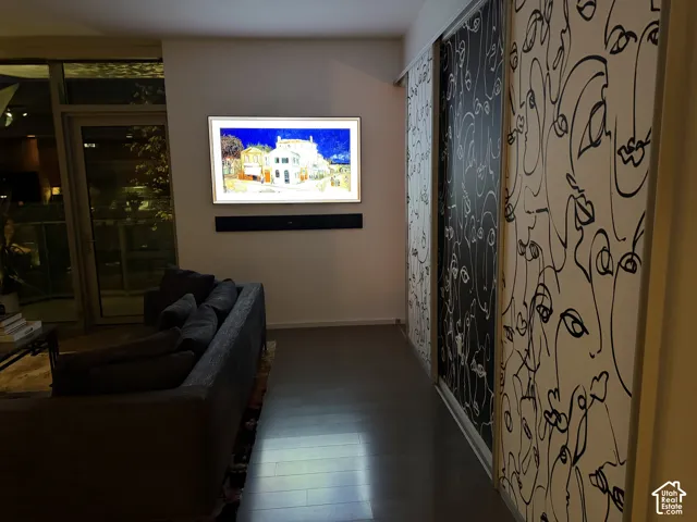 Wall-mounted display, wood-finish flooring, glass paneled door, and patterned sliding panels
