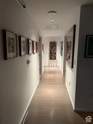 Hallway featuring recessed lighting, wood-finish flooring, and white walls