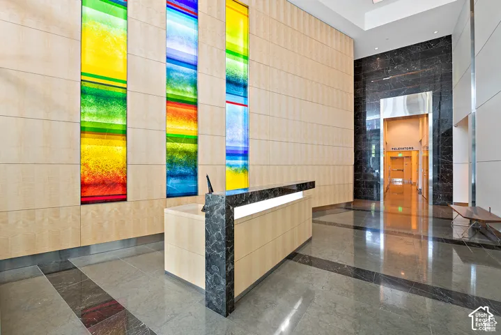 Contemporary reception area featuring a light wood-finish paneled wall with integrated colorful art panels