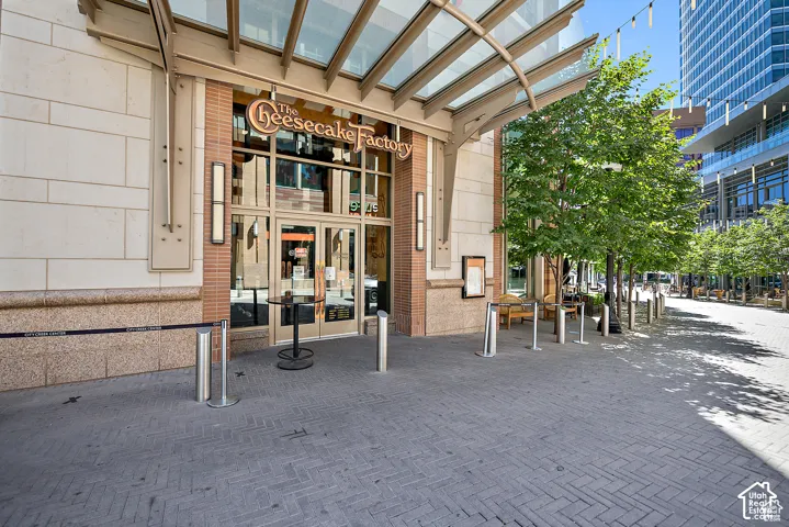 Commercial storefront with a glass and metal canopy entrance, brick and stone facade, and large glass double doors
