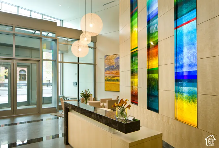 Lobby reception area featuring a polished stone countertop, wood-finish paneling, and integrated colorful art panels