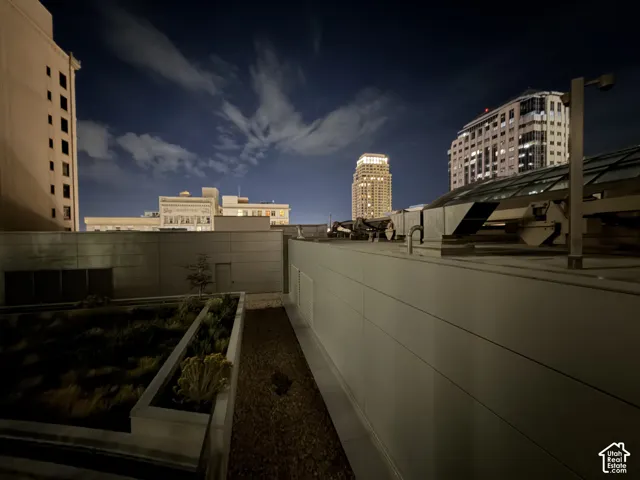 Rooftop terrace with green planters, gravel surfacing, and modern paneling