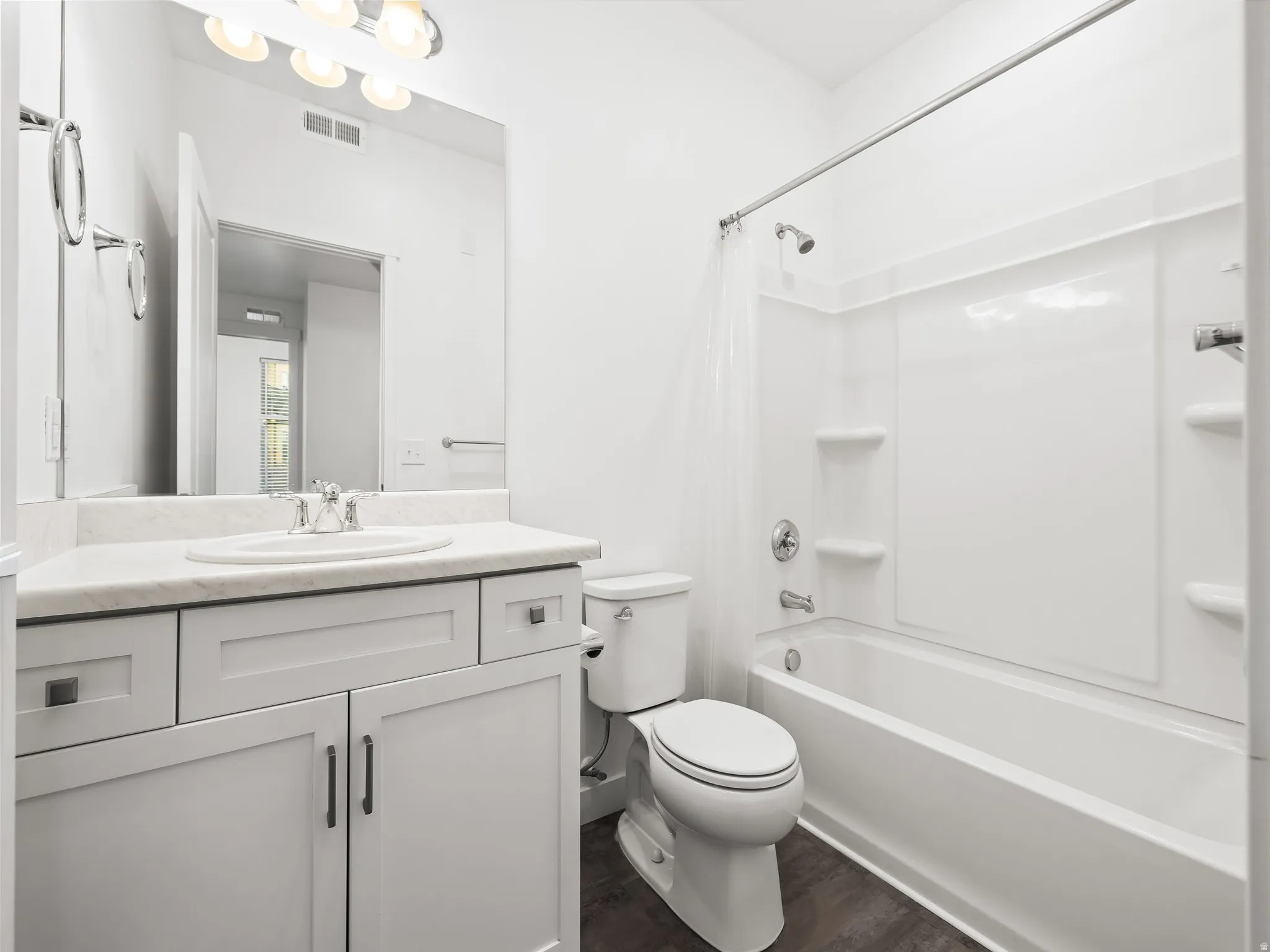 Bathroom featuring a white vanity with panel cabinetry and a light-toned countertop
