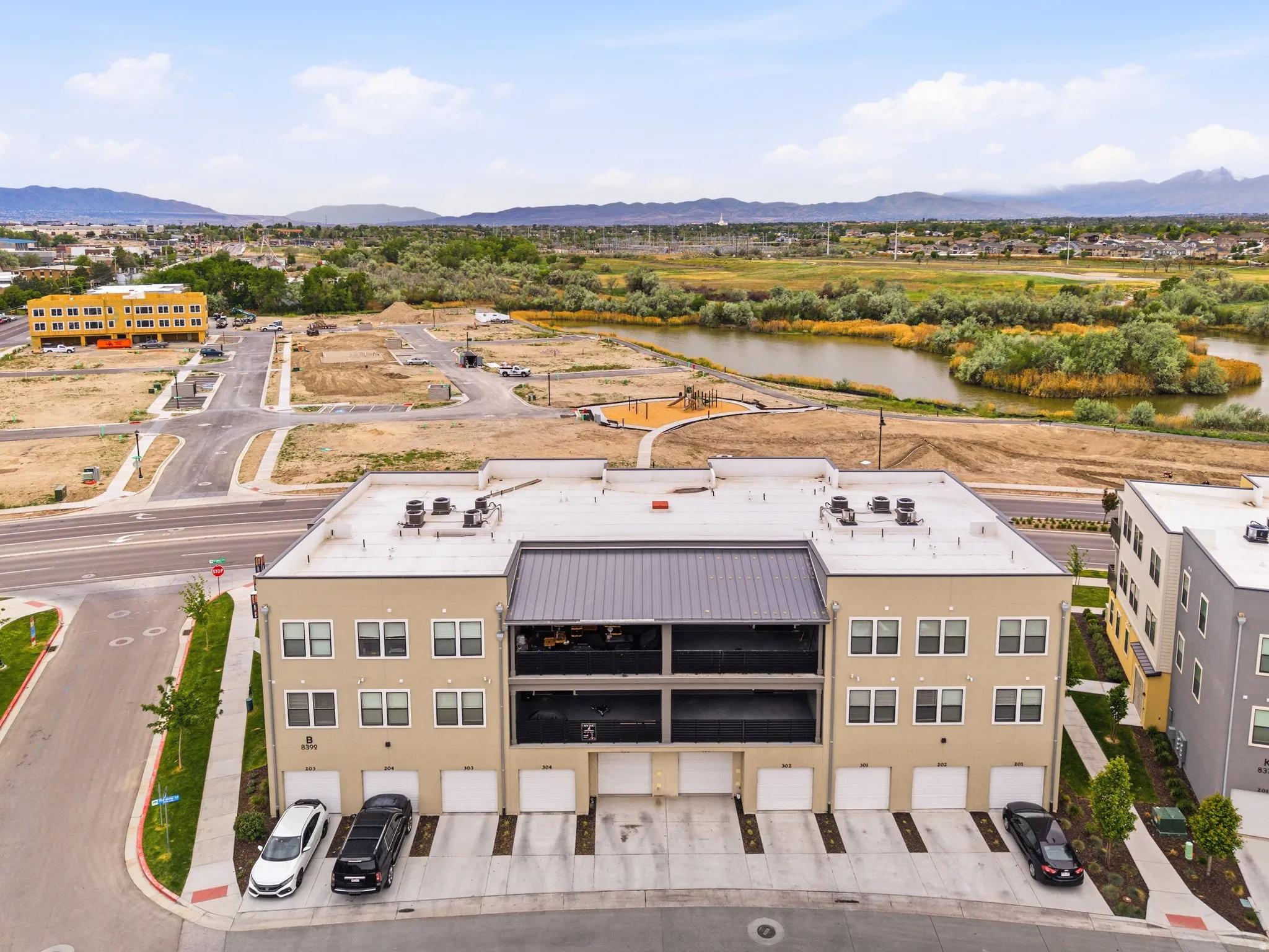 Modern multi-story building featuring individual garage access and a flat roofline