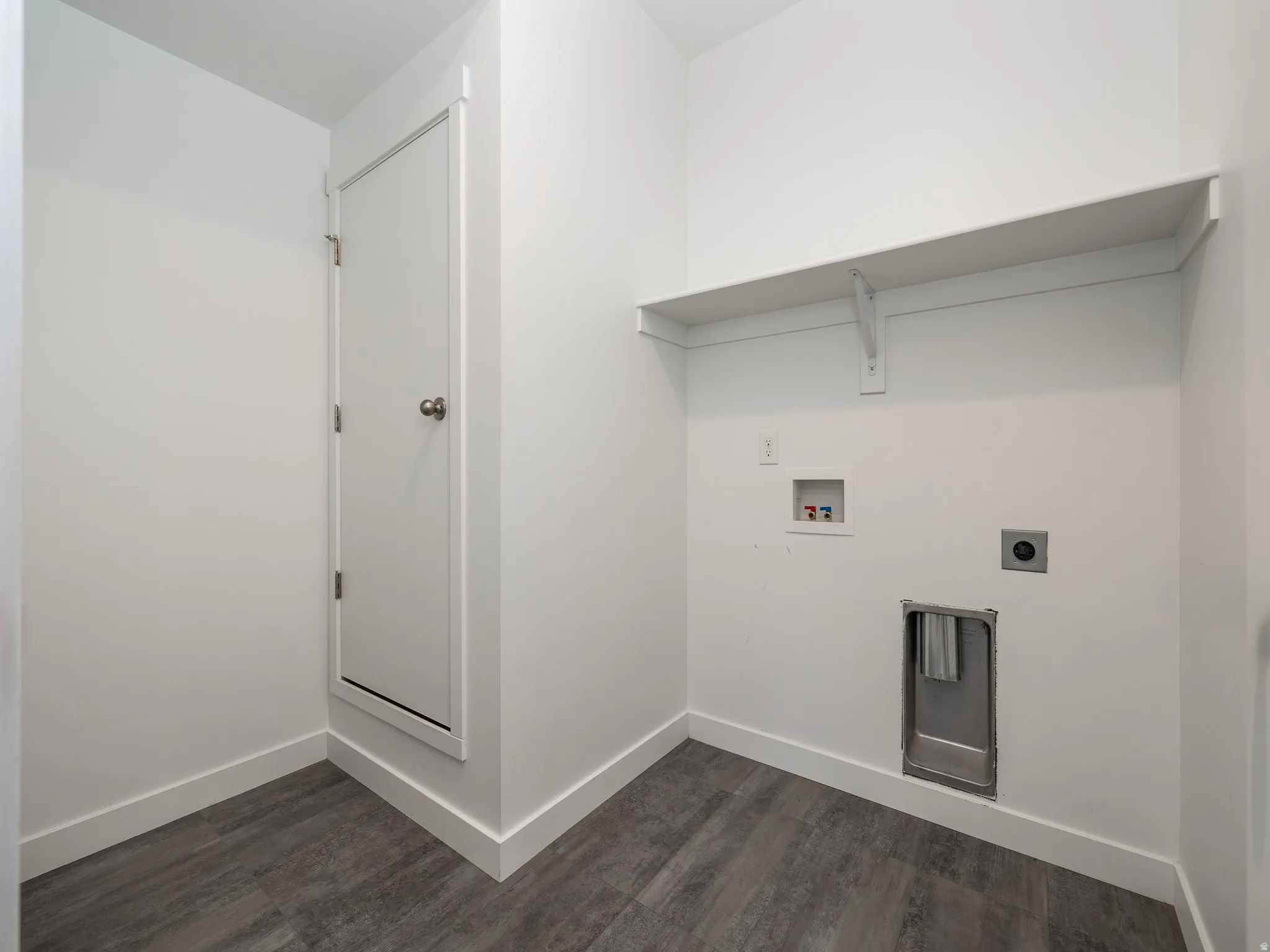 Dedicated laundry area featuring a built-in shelf, plumbing hookups, and wood-finish flooring
